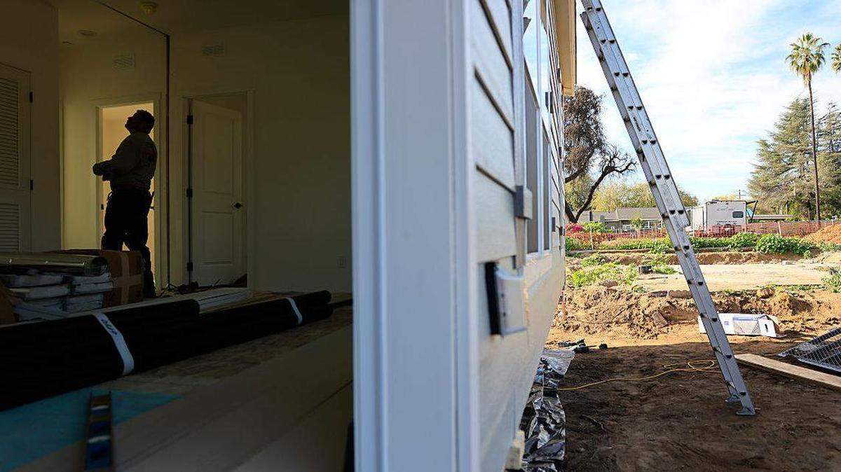 Un trabajador ayuda a ensamblar una vivienda auxiliar prefabricada de 1,200 pies cuadrados el jueves 18 de diciembre de 2025 en Altadena, California.