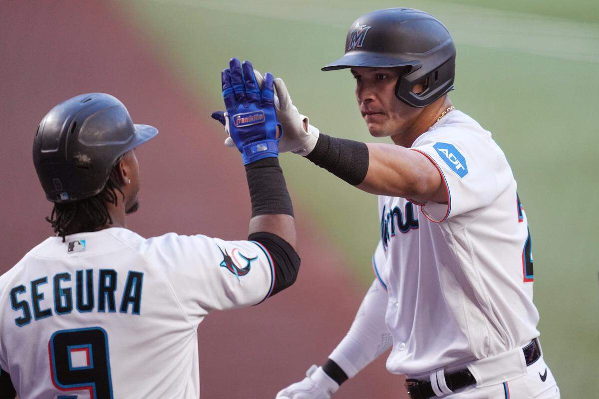 El jardinero de los Marlins Avisaíl García recibe la felicitación de Jean Segura tras pegar un jonrón en el segundo inning del partido ante los Mellizos de Minnesota, celebrado el 4 de abril de 2023 en Miami.