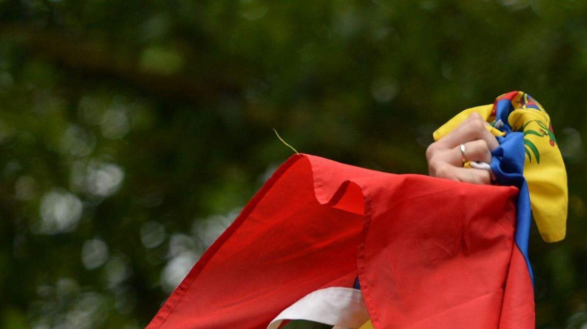 El líder opositor venezolano Leopoldo López muestra la bandera de Venezuela desde su casa, el sábado en Caracas. 