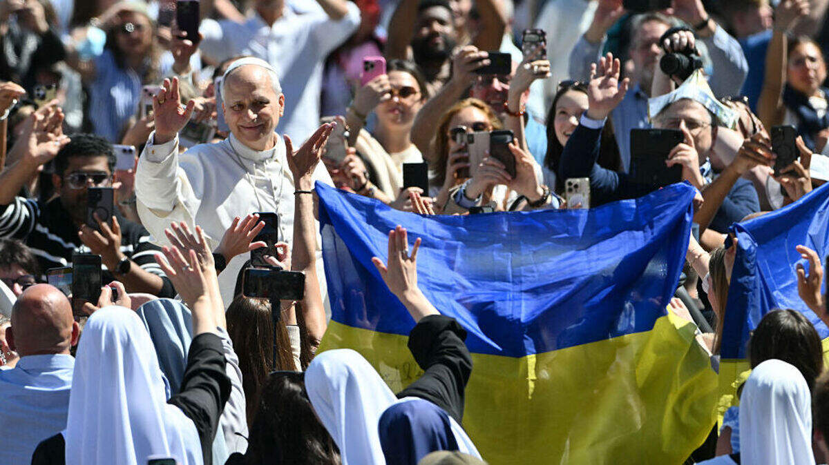 El papa León XIV saluda a la multitud desde el papamóvil, mientras la gente ondea banderas ucranianas, tras la Misa de Pascua como parte de las celebraciones de la Semana Santa, en la plaza de San Pedro, en el Vaticano, el domingo, 5 de abril de 2026.