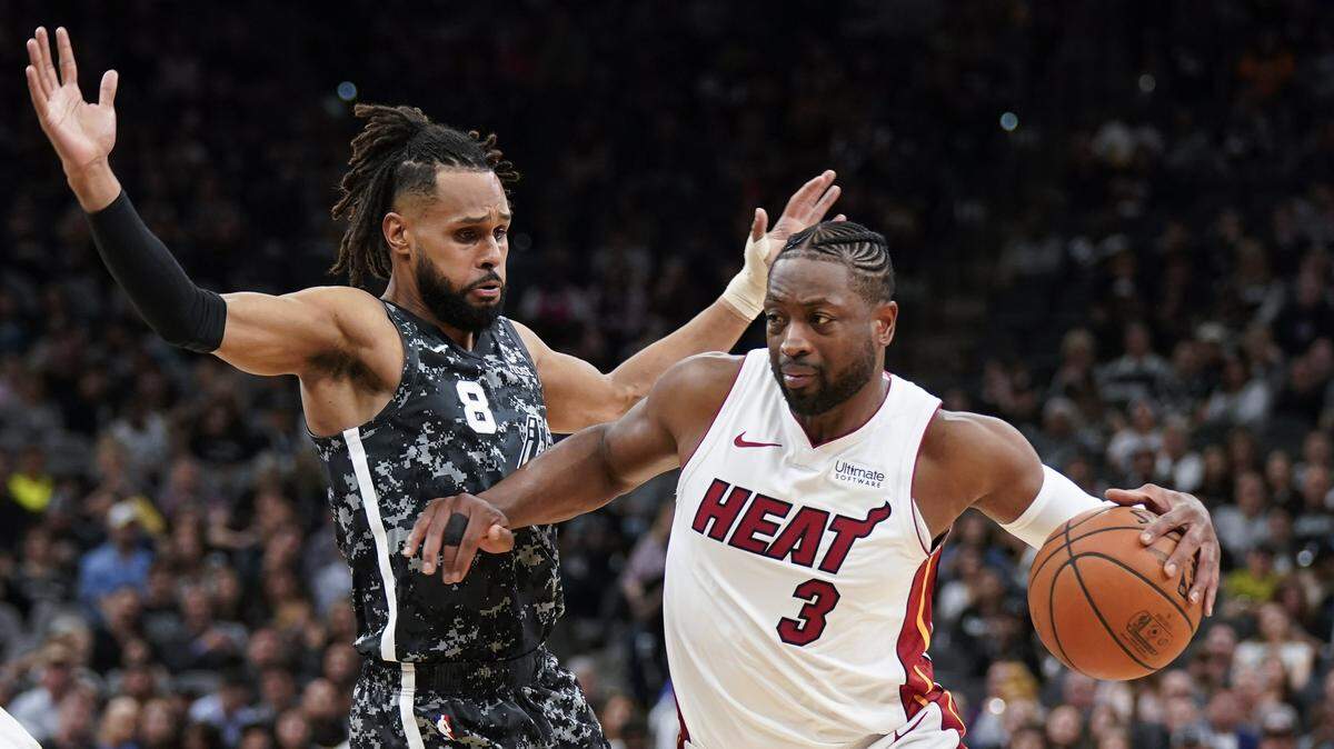 El jugador del Heat Dwyane Wade (der.) entra al aro ante la defensa de Patty Mills, de los Spurs, en el partido celebrado el 20 de marzo de 2019 en San Antonio.