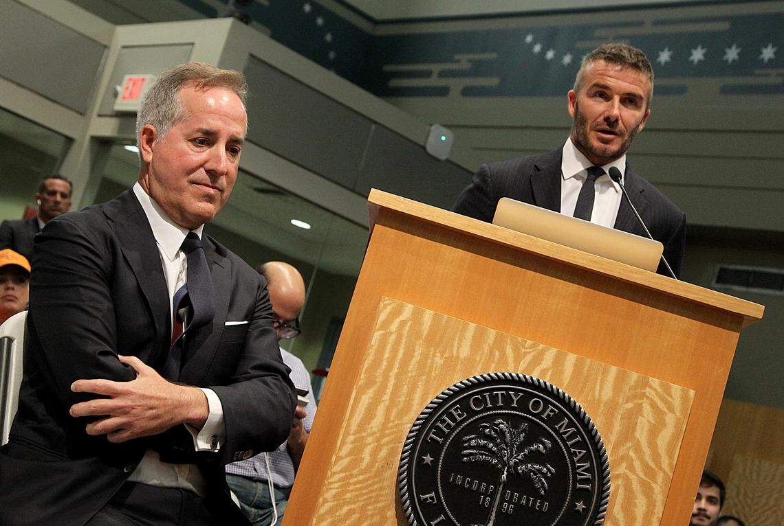 Jorge Mas (izq.) escucha a David Beckham en su presentación en la Comisión de Miami, el 12 de julio de 2018.