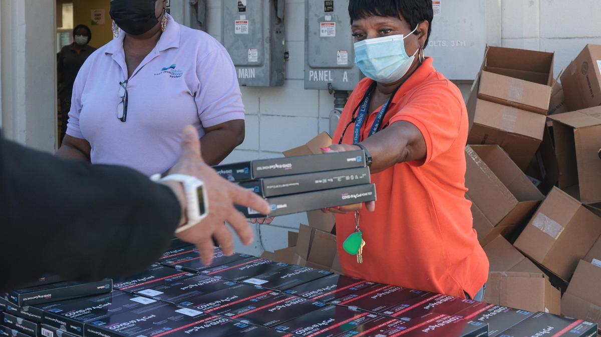 Empleados entregan kits gratis de pruebas caseras del COVID en la Biblioteca Edison el 27 de diciembre de 2021.