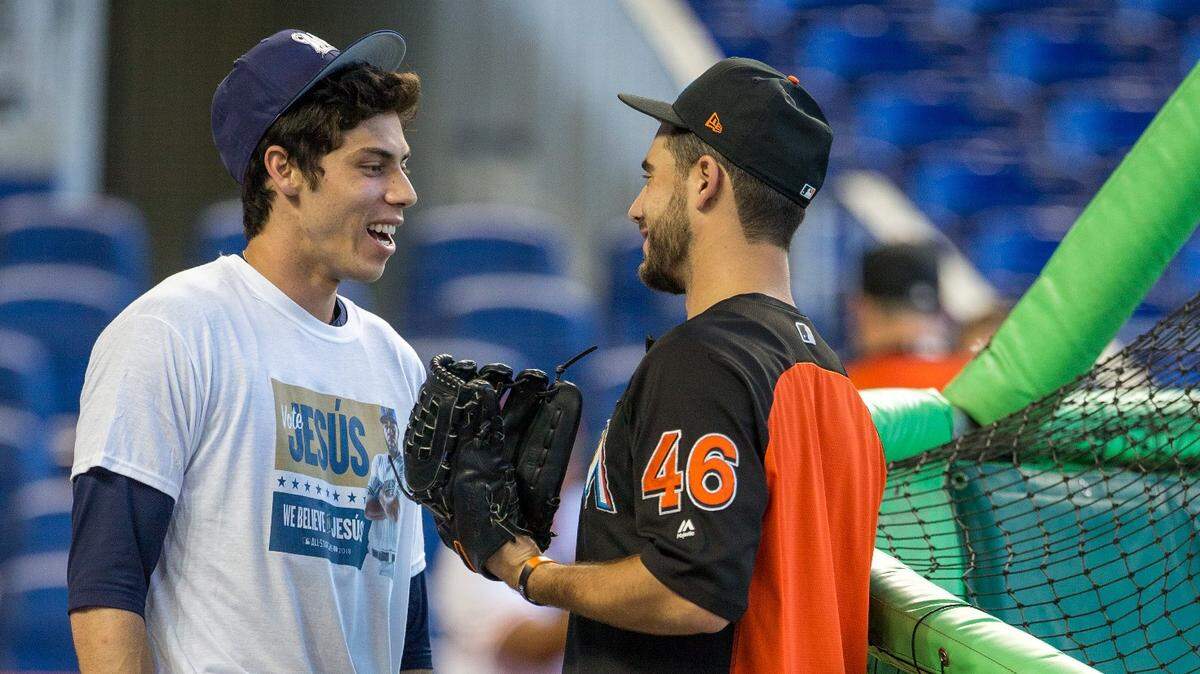 Christian Yelich (izq.) habla con el cerrador de los Marlins Kyle Barraclough, el lunes 9 de julio de 2018 en Miami.