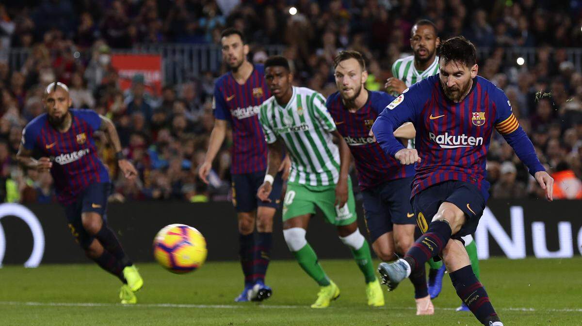 Lionel Messi (der.) anota un penal con Barcelona en el partido ante el Betis en la liga española, el 11 de noviembre de 2018.