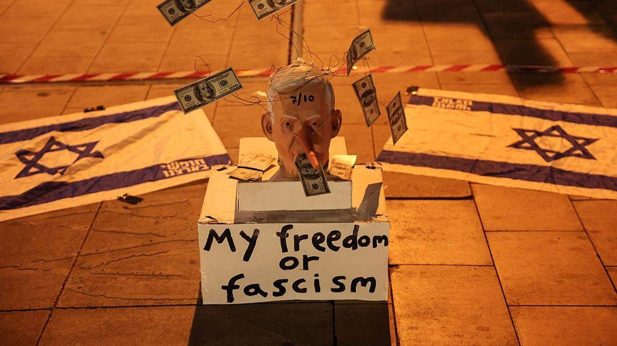 A mask mocking Israeli Prime Minister Benjamin Netanyahu is placed on the street during a demonstrate against him and in support of establishing a state commission of inquiry into Hamas' October 7, 2023 attacks on Israel, on Habima Square in Tel Aviv on November 15, 2025. (Photo by Jack GUEZ / AFP) (Photo by JACK GUEZ/AFP via Getty Images)