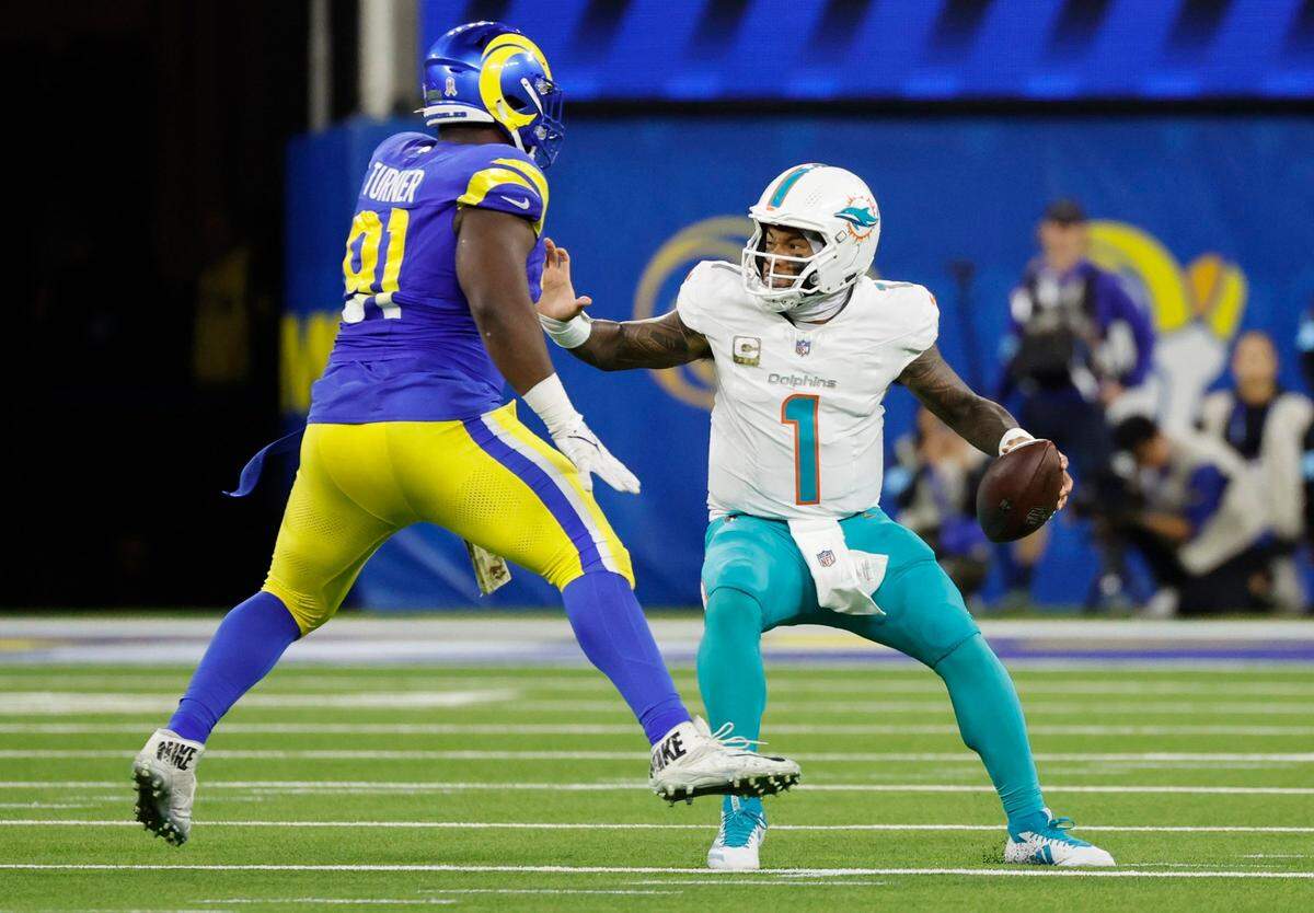 El quarterback de los Dolphins de Miami Tua Tagovailoa trata de evadir al defensive tackle de los Rams Kobie Turner,  en el partido efectuado el 11 de noviembre de 2024 en el SoFi Stadium en Inglewood, California.