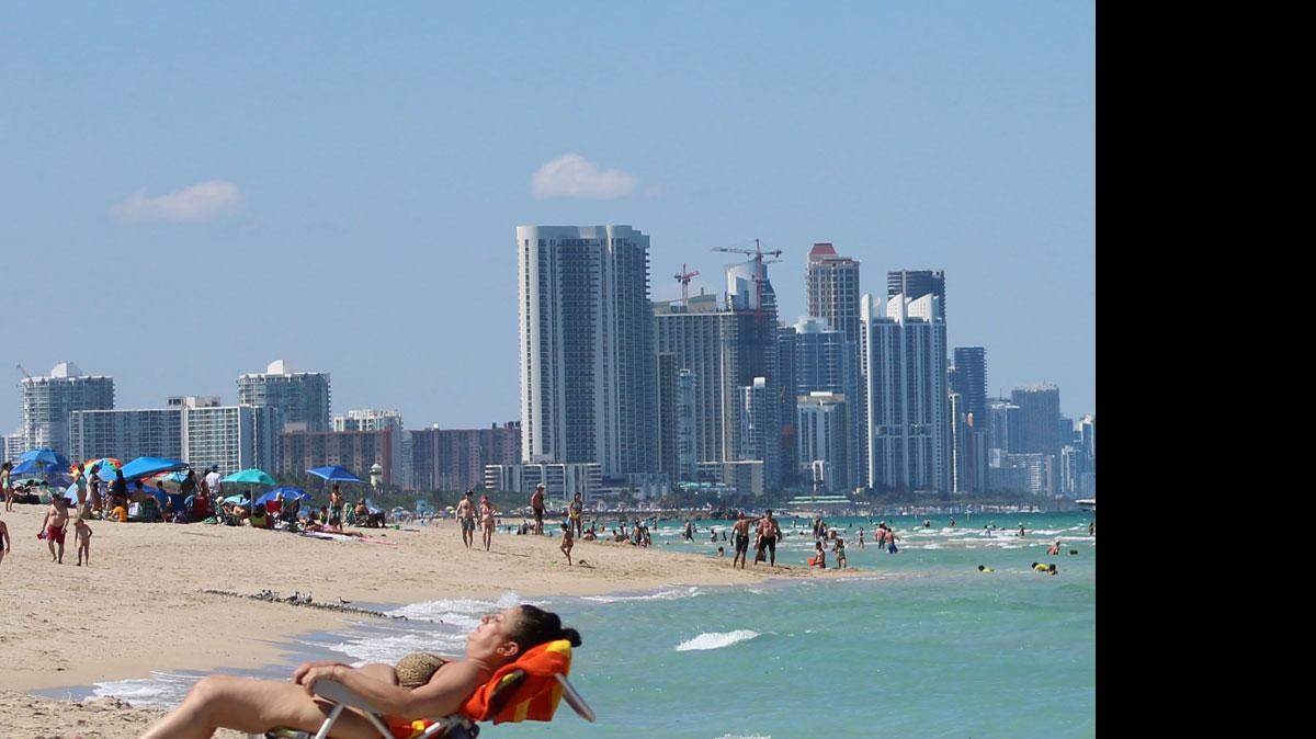 Una mujer toma sol en la playa de Surfside. Florencia Paz/El Nuevo Herald