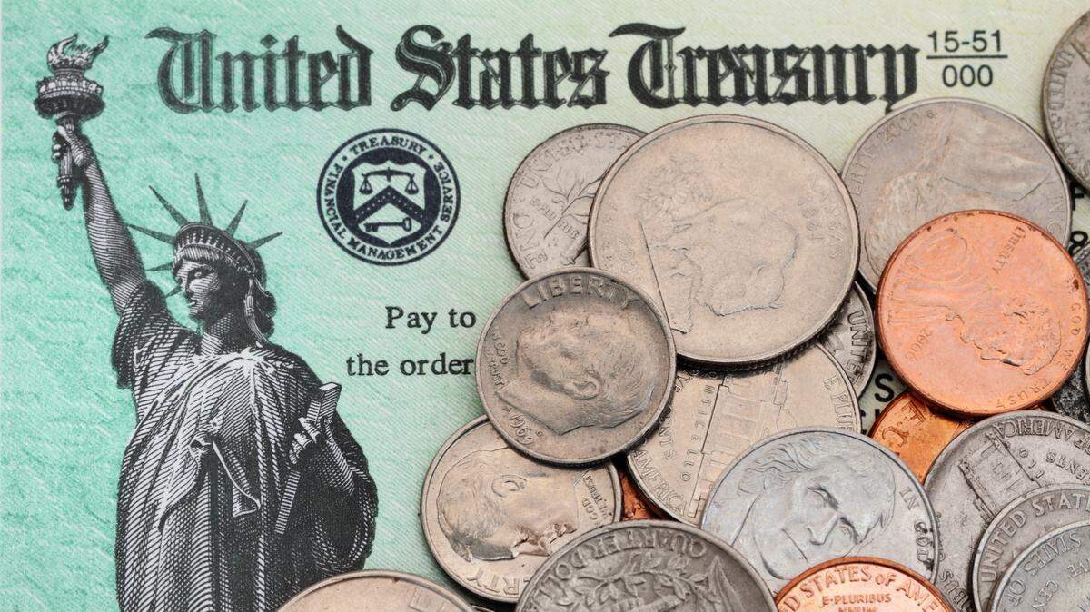 US coins are scattered across an IRS tax refund check