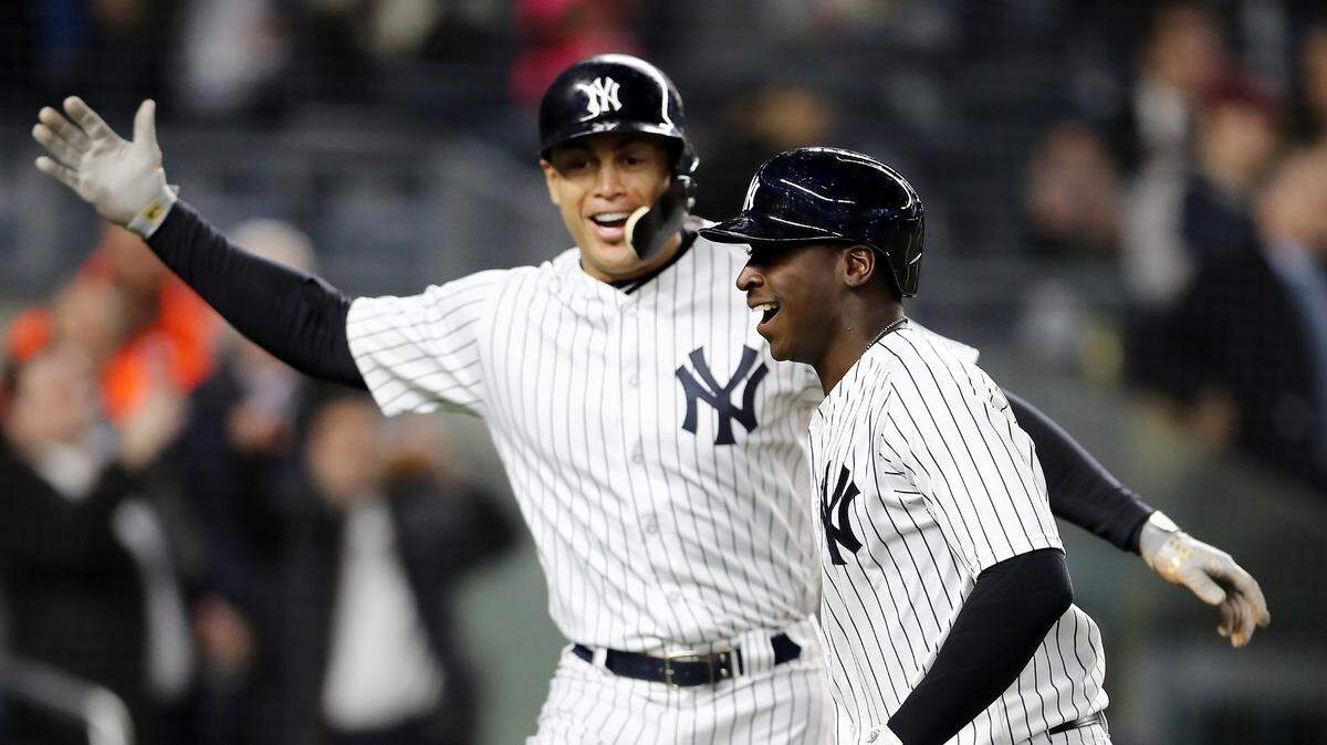 Giancarlo Stanton (izq.) celebra con Didi Gregorius luego del cuadrangular del torpedero de los Yankees ante los Marlins, en el partido celebrado el 16 de abril de 2018 en Nueva York.