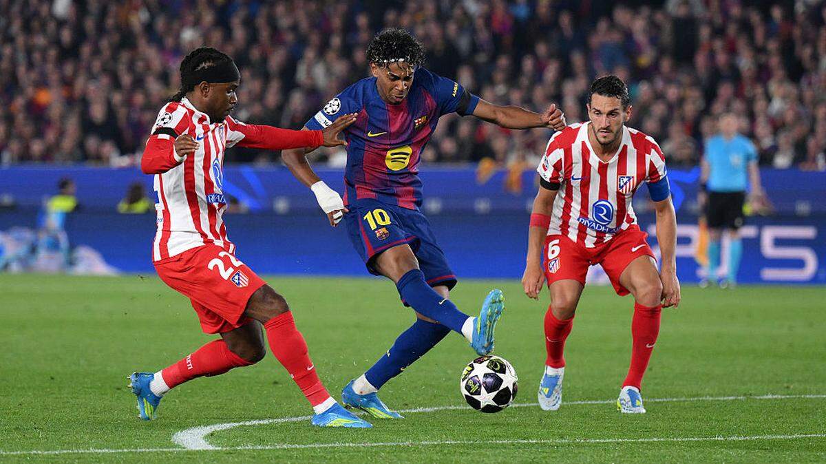 El astro de Barcelona Lamine Yamal (centro) trata de pasar la marca de Ademola Lookman (izq.) y Koke, del Atlético de Madrid, en el partido de ida de los cuartos de final de la Liga de Campeones celebrado el 8 de abril de 2026 en Barcelona. 