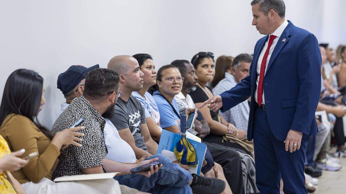 El recaudador de impuestos del Condado Miami-Dade, Dariel Fernández, conversa con Yasmani Solis, de 37 años y residente de La Pequeña Habana, mientras este espera en la fila en el Centro de Servicios de Licencias de Conducir y Vehículos Motorizados del Departamento de Seguridad Vial de Florida el 16 de abril de 2025 en Miami, Florida.
