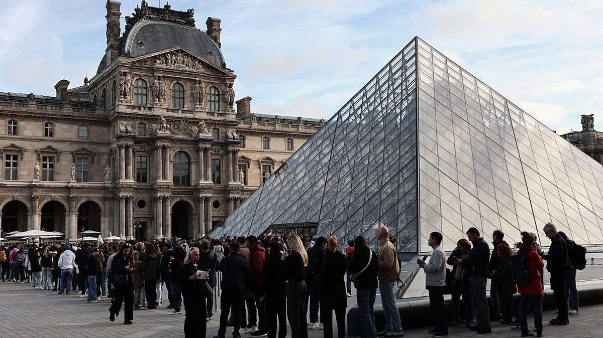 Visitors queue in front of the Pyramide du Louvre, designed by Chinese-US architect Ieoh Ming Pei, with the Louvre Museum in the background in Paris on October 22, 2025. The Louvre Museum reopened its doors to visitors on October 22, 2025 morning for the first time since October 19, 2025's spectacular robbery by four criminals, who made off with eight jewels worth an estimated 88 million, an AFP journalist reported. (Photo by Thibaud MORITZ / AFP) (Photo by THIBAUD MORITZ/AFP via Getty Images)