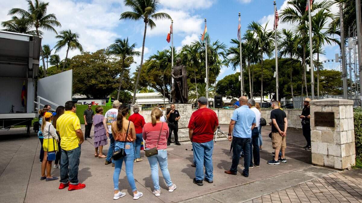 Los manifestantes escuchan al presidente de Ciudadanos Independientes Venezolanos Americanos (IVAC), Ernesto Ackerman, durante una protesta organizada por IVAC frente a la estatua del prócer venezolano Simón Bolívar en Miami, Florida, el domingo 20 de marzo de 2022.