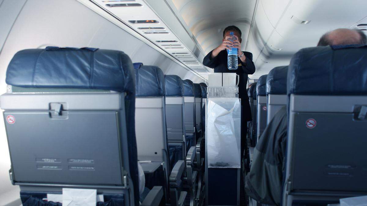 A flight attendant on the job, in a small plane.