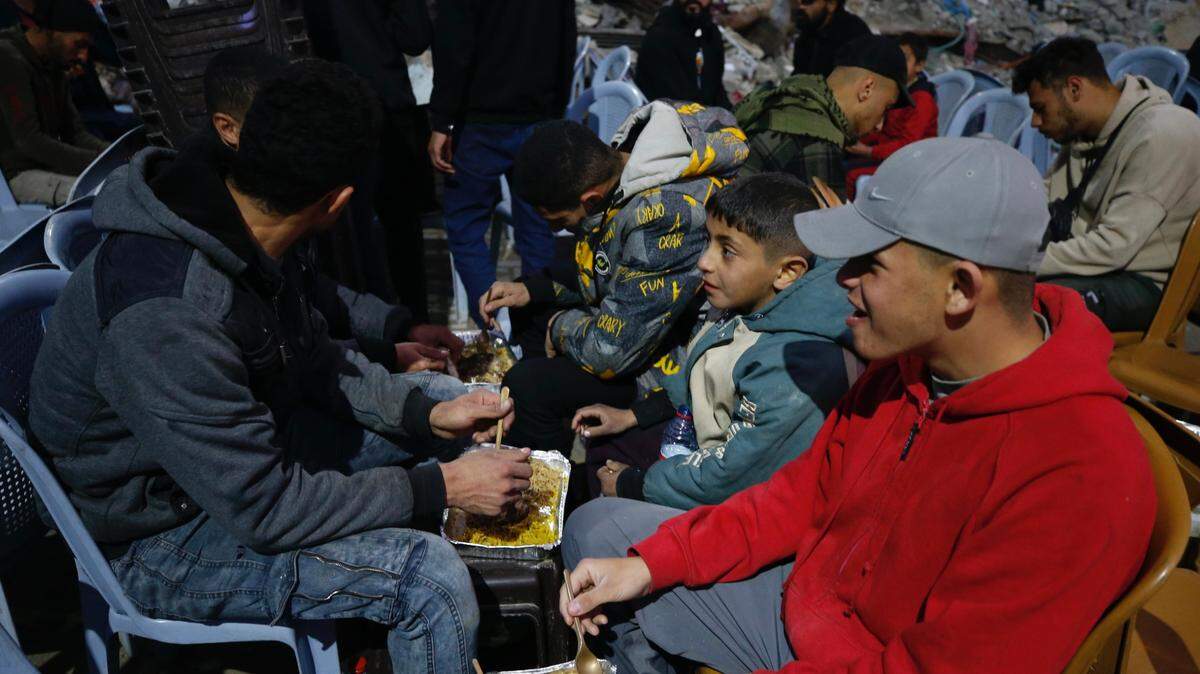 Palestinos consumen su comida entre casas destruidas después del ayudo celebrado durante el primer día de Ramadán, el sábado 2 de marzo de 2025, en Jabalia, en el norte de Gaza.