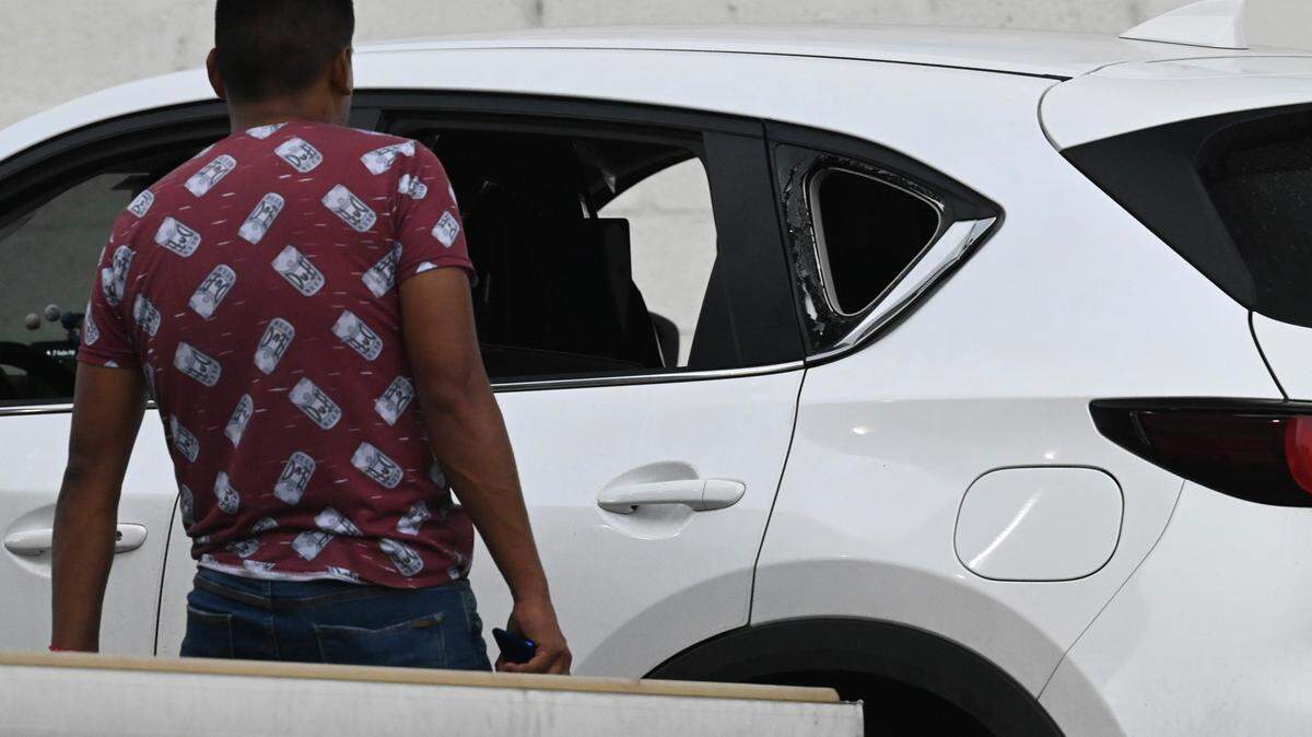 Un investigador examina el vehículo que manejaba el fiscal César Suárez cuando fue asesinado en Guayaquil, Ecuador, el miércoles 17 de enero de 2024.