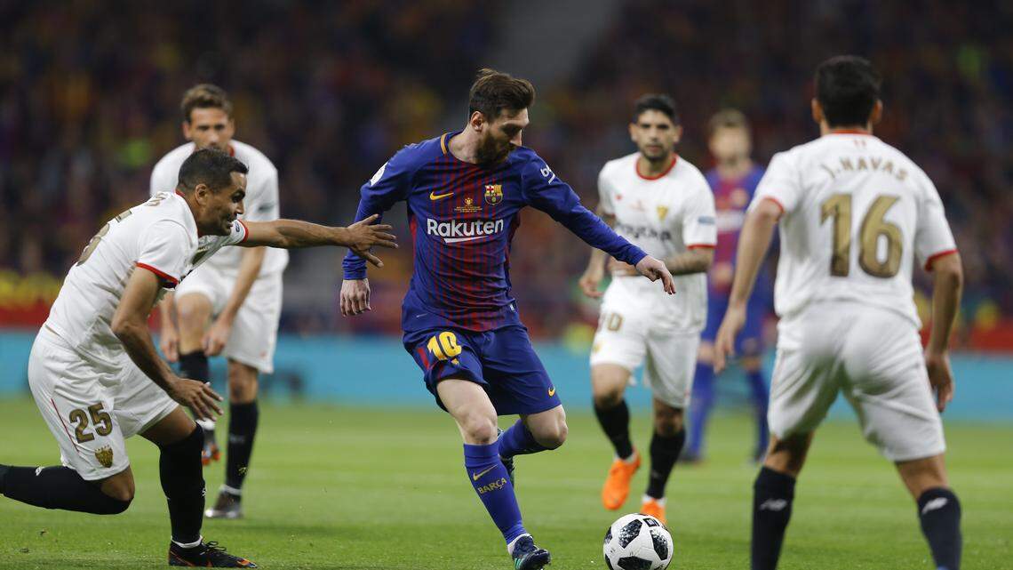 El delantero de Barcelona Lionel Messi (centro) trata de avanzar ante la defensa del Sevilla, en la final de la Copa del Rey, celebrada el 21 de abril de 2018.