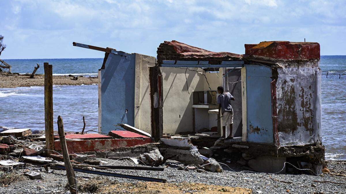 Un hombre se encuentra junto a una casa dañada después del paso del huracán Melissa en Boca de Dos Ríos, provincia de Santiago de Cuba, Cuba, el 30 de octubre de 2025.