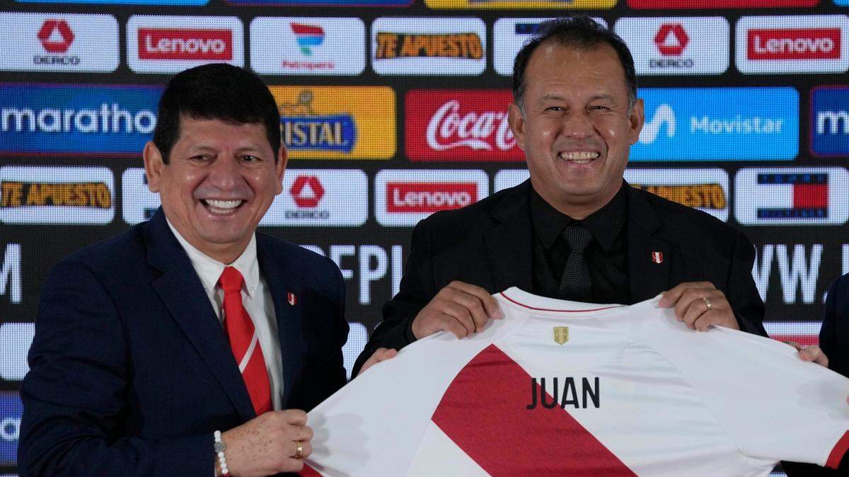 Juan Reynoso (der.) y el presidente de la Federación Peruana de Fútbol, Agustín Lozano, sostienen una camiseta de fútbol personalizada durante la primera conferencia de prensa de Reynoso como nuevo entrenador de la selección nacional de ese país en Lima, Perú, el miércoles 3 de agosto de 2022.