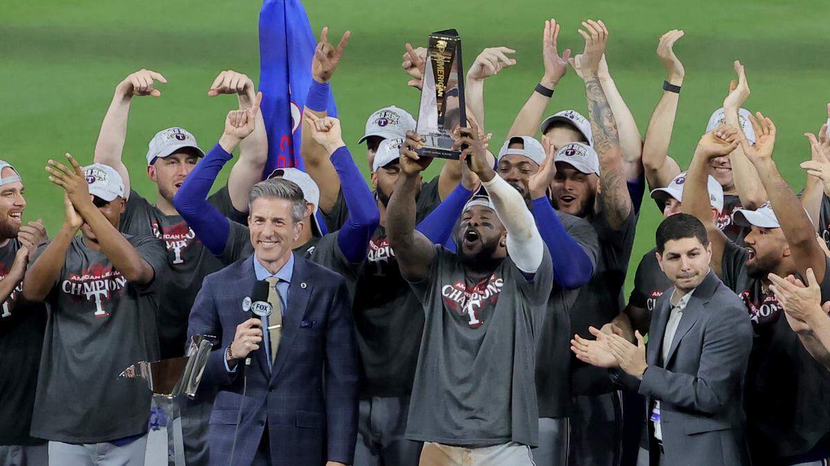 El jardinero cubano de los Rangers de Texas Adolis García celebra con el trofeo de Jugador Más Valioso de la Serie de Campeonato de la Liga Americana que recibió este lunes, luego del triunfo en el séptimo juego ante los Astros en Houston.