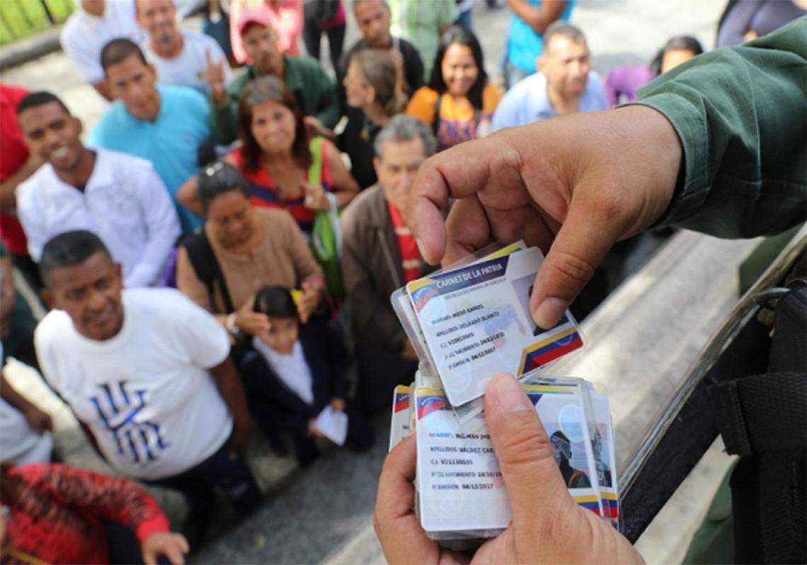 Un agente del gobierno revisa "Carnets de la Patria" en Venezuela.