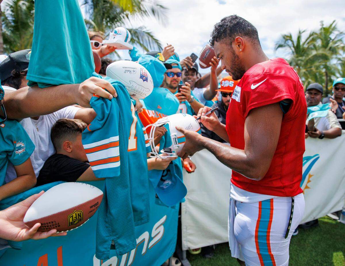 El quarterback de los Dolphins Tua Tagovailoa firma autógrafos durante una práctica celebrada el 2 de agosto de 2022 en el Baptist Health Training Complex en Miami Gardens, Florida.