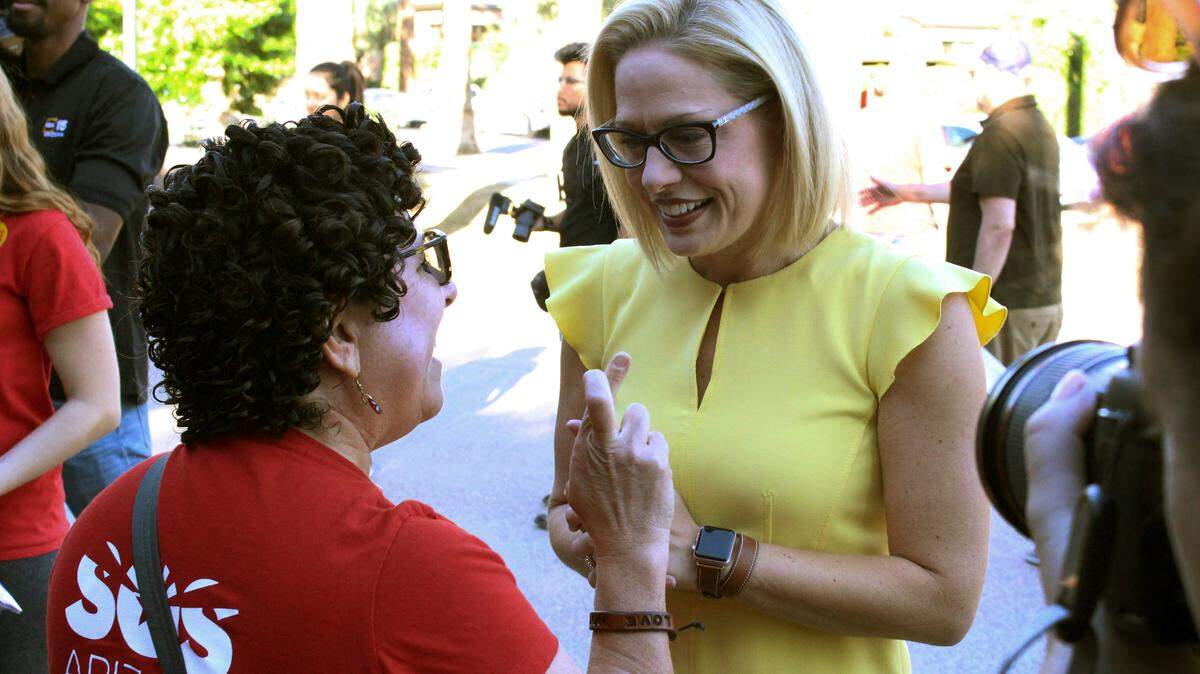 La candidata al Senado de EEU,  Kyrsten Sinema, conversa con una simpatizante en Phoenix, Arizona, el 3 de noviembre del 2018.