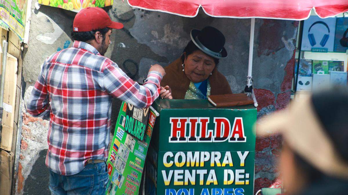 Una hombre realiza el cambio de divisas este jueves, en el centro de La Paz (Bolivia). La economía boliviana, que en los últimos dos años dejó de percibir entre $5,000 millones y $8,000 millones por factores como la caída de las exportaciones de gas natural, corre el riesgo de ahogarse por la falta de divisas y las restricciones crecientes para hacer transacciones en esa moneda, advirtieron sectores productivos.