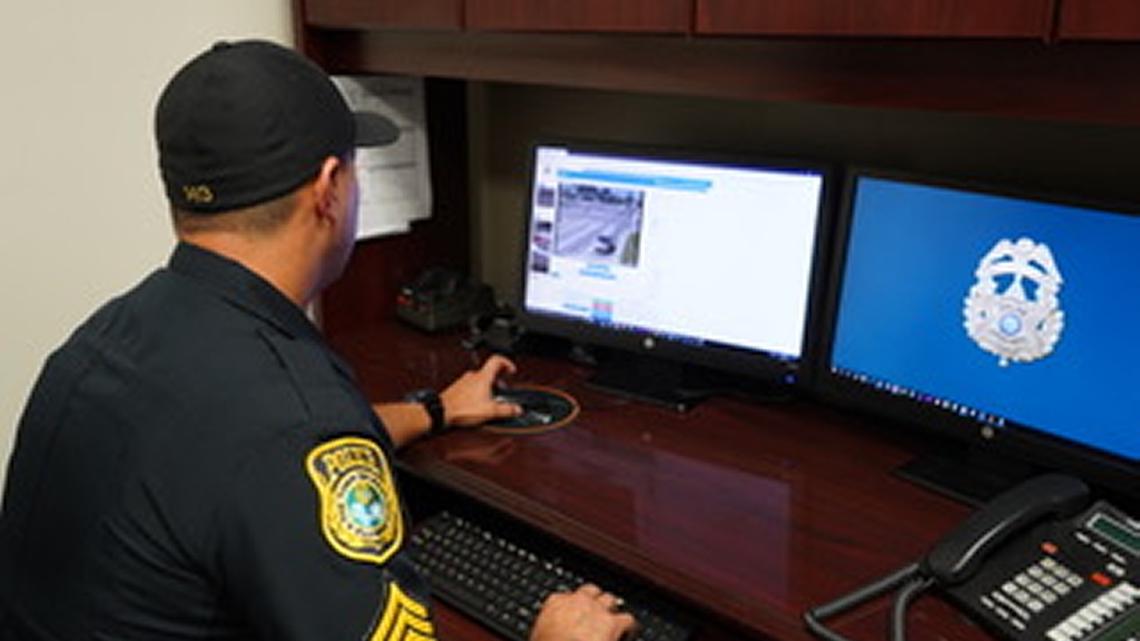 Un oficial de la Policía de Medley revisa el sistema de cámaras en los semáforos.