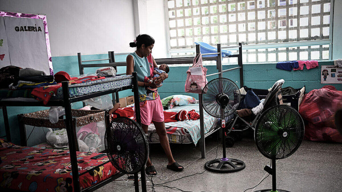 Scarlett Goitía carga al bebé de su hermana Eliana García en un refugio en la Escuela Bolivariana 10 de Marzo en Maiquetía, estado La Guaira, Venezuela, el 7 de julio de 2026.