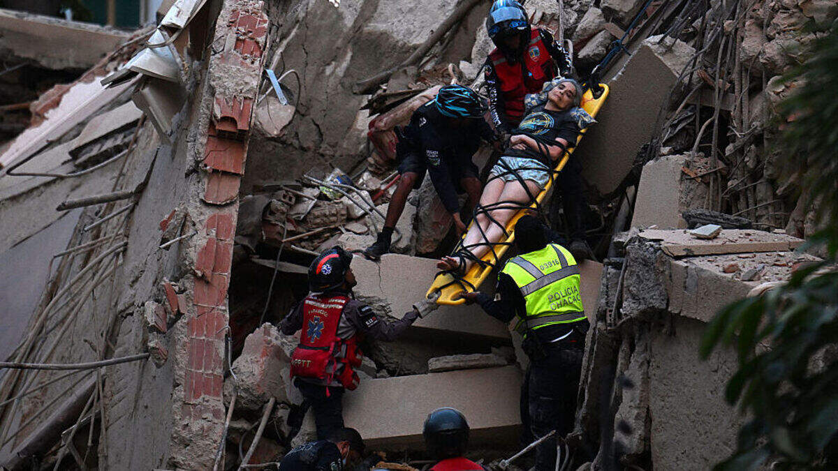 Rescue workers carry a person on a stretcher out of a collapsed building following an earthquake in Caracas on June 24, 2026.