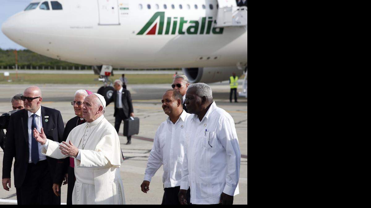 El papa Francisco llega al aeropuerto Antonio Maceo donde es recibido por un coro de niños el lunes 21 de septiembre de 2015, en Santiago de Cuba (Cuba) como parte de su programa de actividades eclesiásticas en el marco de su visita desde donde partirá mañana, martes, hacia EEUU. 