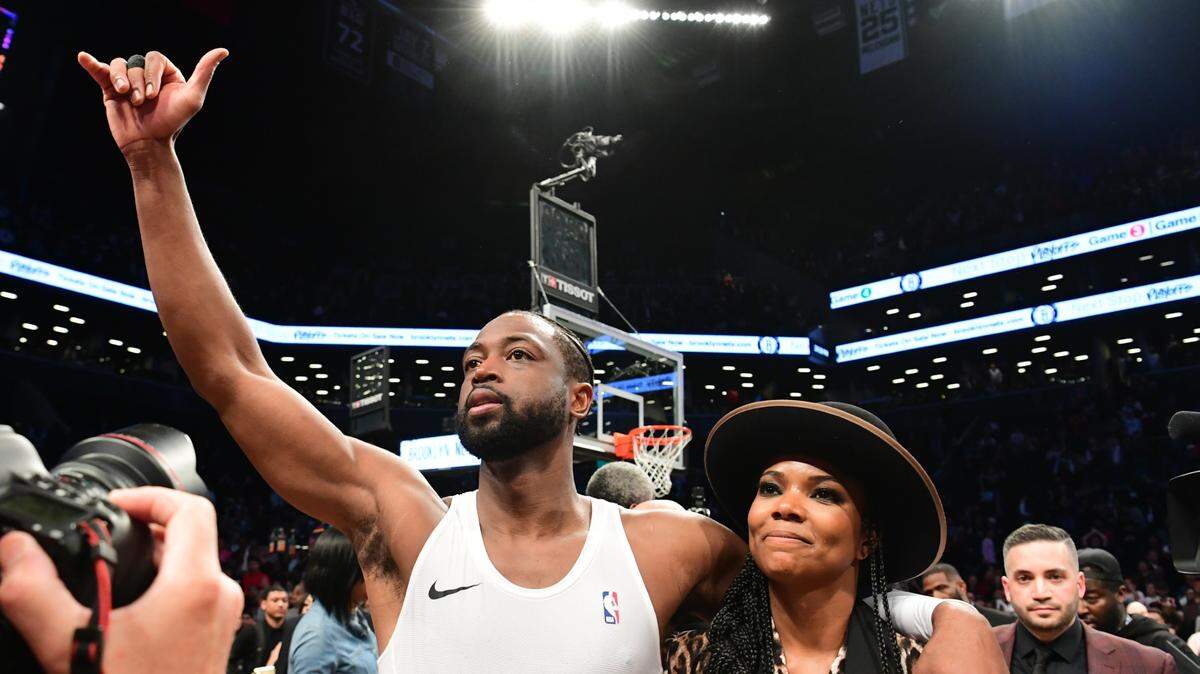 Dwyane Wade se despide del público en el Barclays Center de Brooklyn acompañado de su esposa Gabrielle Union, luego del final del partido entre el Heat y los Nets, el 10 de abril de 2019.