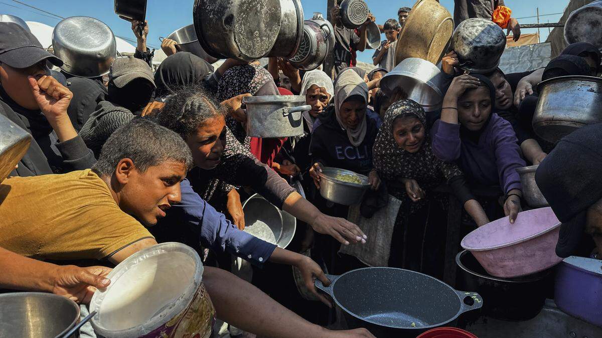 Palestinos desplazados hacen largas filas para recibir una comida benéfica bajo carpas abarrotadas en Khan Yunis, Gaza, el 7 de septiembre de 2025, mientras la escasez de alimentos se agrava bajo el asedio en curso. Mujeres y niños dependen de pequeñas cocinas comunitarias para alimentar a miles en medio de una lucha diaria por sobrevivir.