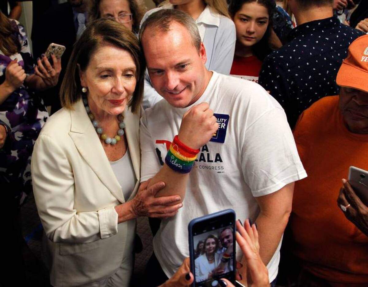 La líder de la minoría de la Cámara de Representantes, Nancy Pelosi, se toma una foto junto a un simpatizante en el acto de campaña del 17 de ocutbre del 2018 en la oficina de campaña de Donna Shalala.