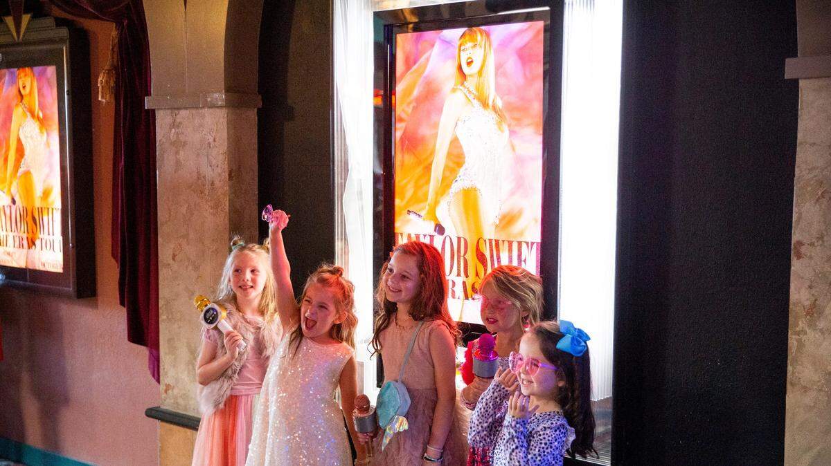 Varias niñas posan frente al afiche de la película “Taylor Swift: The Eras Tour”, en Malco Paradiso Cinema Grill and IMAX en Memphis, Tennessee, el sábado 14 de octubre de 2023.