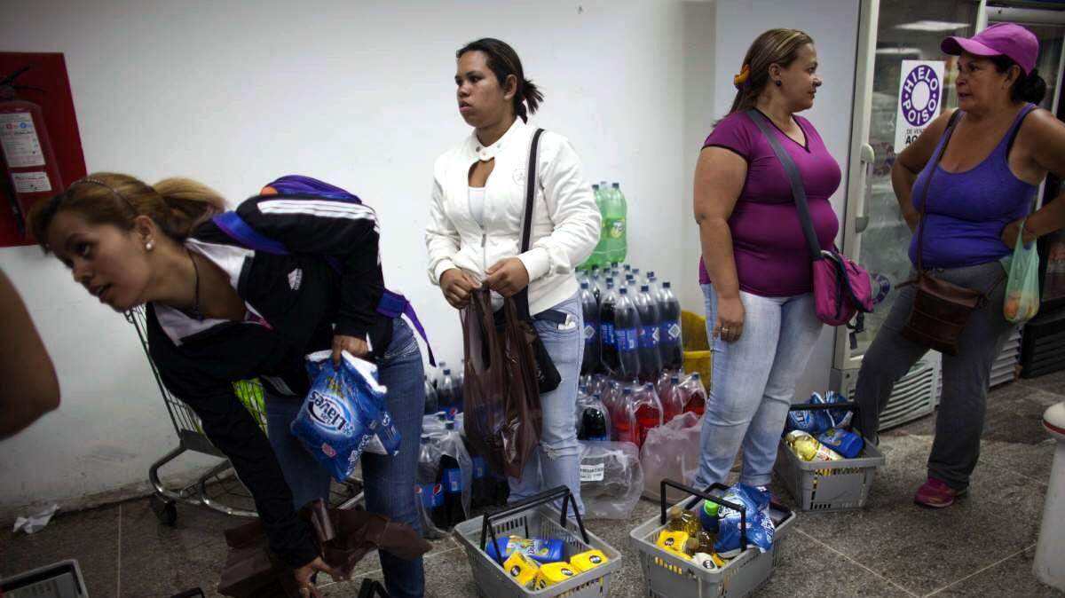 Compradores hacen cola para comprar alimentos en Venezuela. AP/Archivo