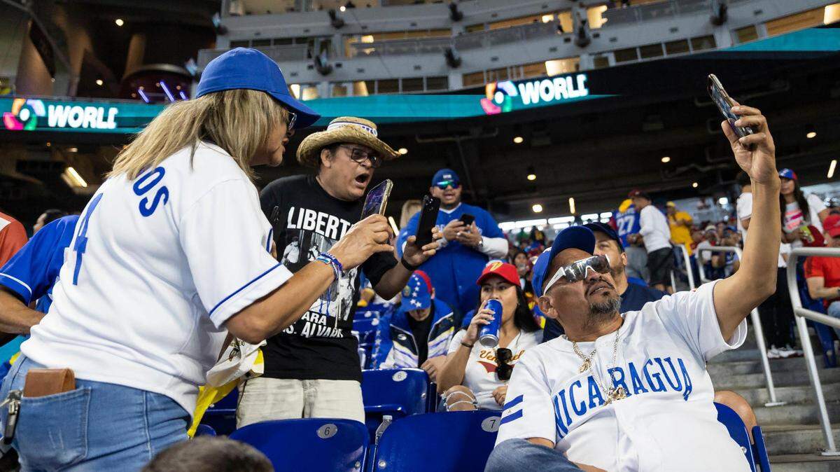 Integrantes del público le gritan al presunto paramilitar Juan Caldera, sentado a la derecha, durante la primera entrada del juego entre Nicaragua y Venezuela del Clásico Mundial de Béisbol en el LoanDepot Park el martes 14 de marzo de 2023 en Miami, Florida.