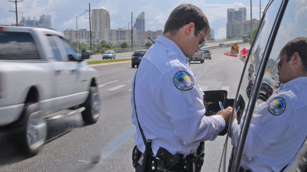 In this file photo from June 12, 2008, a Sunny Isles Beach police officer tickets a driver for violating the Florida Move-Over Law. The law is now expanded for 2024.