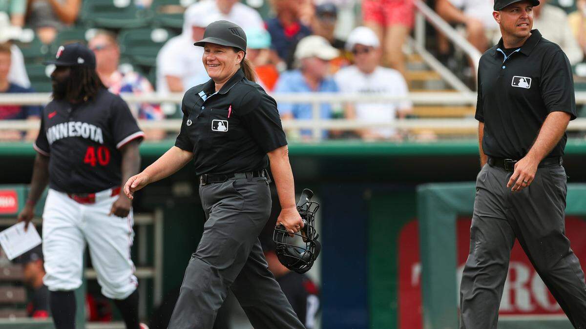 La árbitra Jen Pawol sonríe mientras entra al terreno antes de un partido en el entrenamiento de primavera entre los Mellizos de Minnesota y los Rockies de Colorado, el 25 de marzo de 2025 en Fort Myers, Florida.