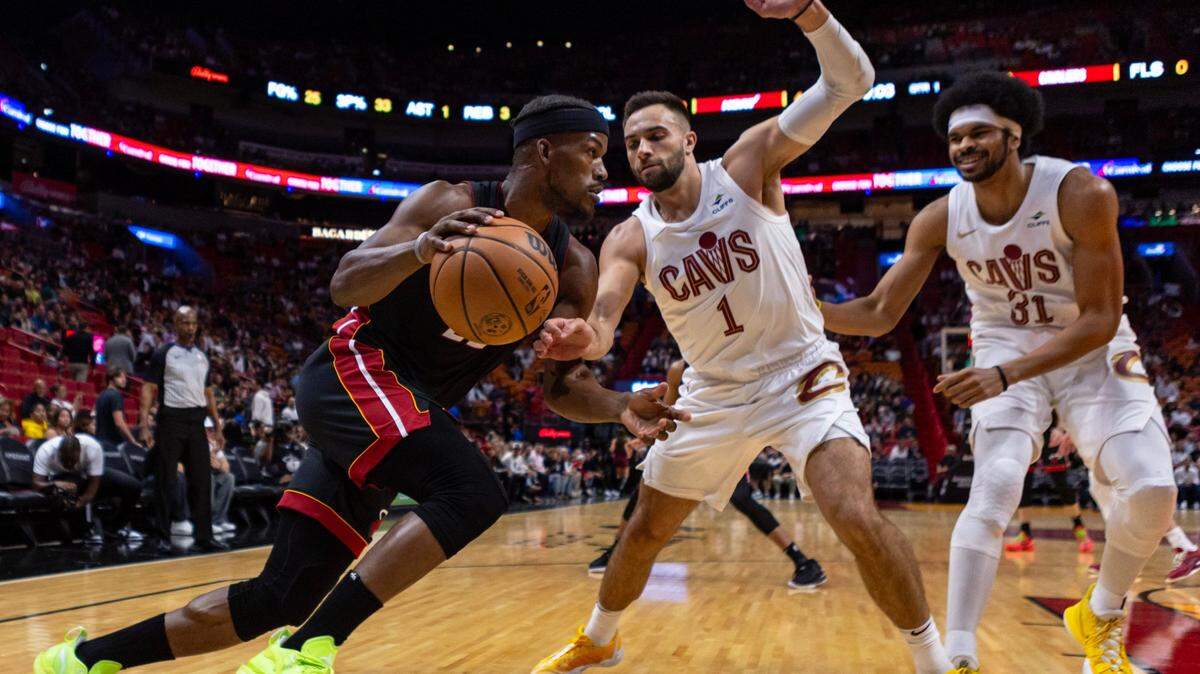 El delantero del Miami Heat, Jimmy Butler (22), entra al aro ante el escolta de los Cleveland Cavaliers, Max Strus (1), el viernes 8 de diciembre de 2023. en el Kaseya Center de Miami, Florida.