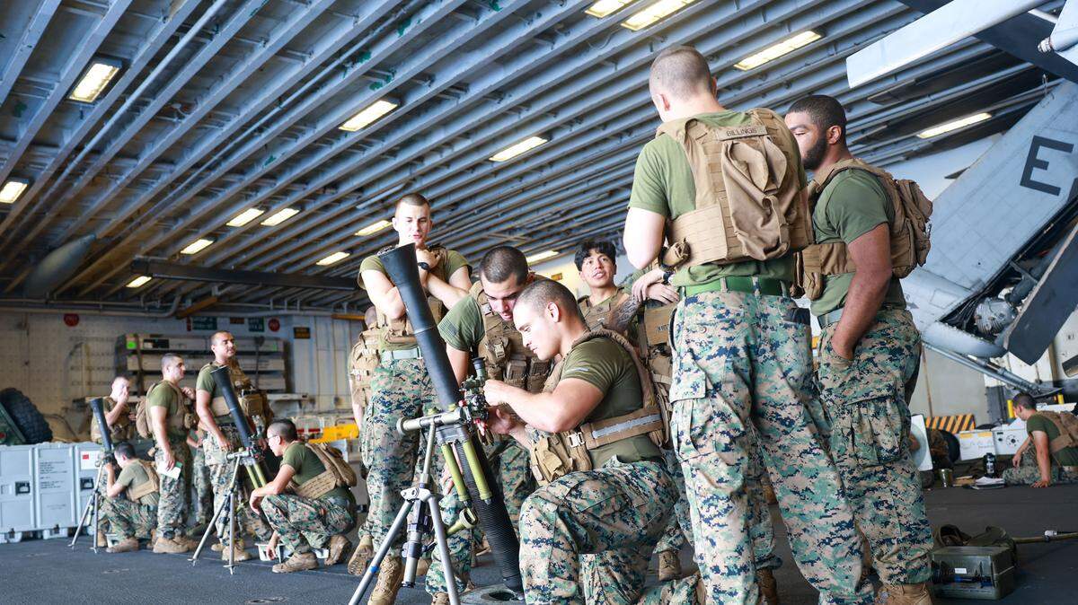 Marines estadounidenses, asignados a la 22.a Unidad Expedicionaria de Infantería de Marina (MEU) con Capacidad de Operaciones Especiales (SOC), disparan un mortero durante una misión de fuego simulado en el hangar del USS Iwo Jima, en el océano Atlántico, cerca de las costas venezolanas, el lunes 25 de agosto de 2025.