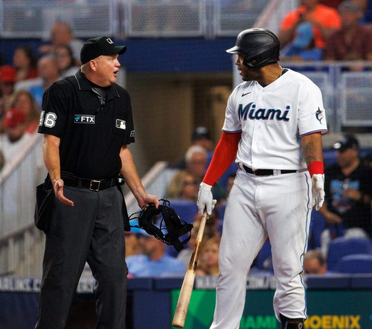 El bateador designado de los Marlins Jesús Aguilar habla con el árbitro de home Ron Kulpa en el segundo del partido contra los Filis de Filadelfia, celebrado el 17 de julio de 2022 en Miami.