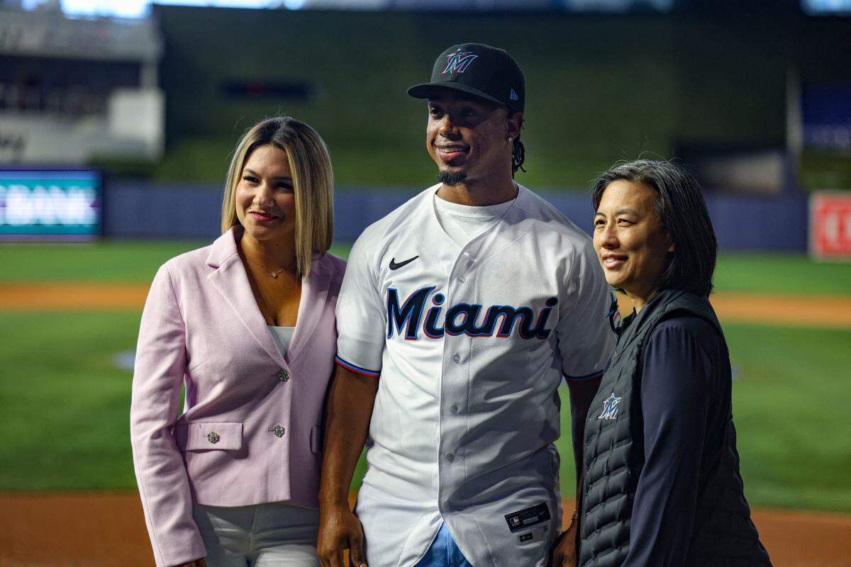 Jean Segura, la gerente general de los Marlins Kim NG (der.) y su esposa Kellen en la presentación del pelotero dominicano como nuevo jugador de la novena de Miami, el 11 de enero de 2023 en el loanDepot Park en la Pequeña Habana.