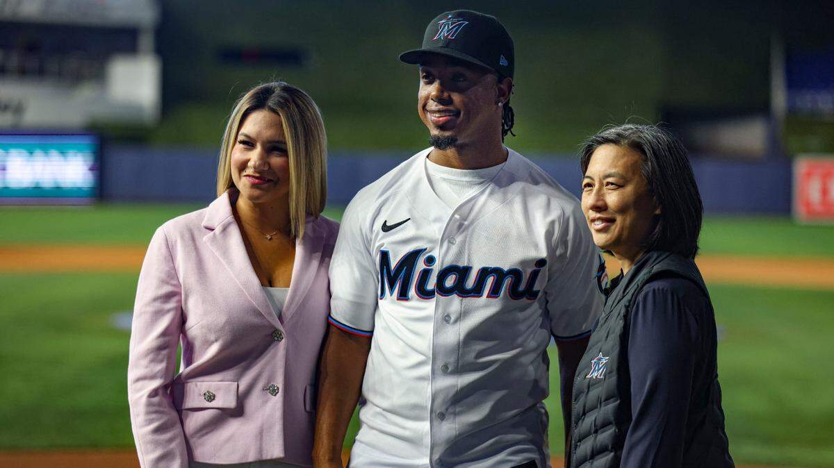 Jean Segura, la gerente general de los Marlins Kim NG (der.) y su esposa Kellen en la presentación del pelotero dominicano como nuevo jugador de la novena de Miami, el 11 de enero de 2023 en el loanDepot Park en la Pequeña Habana.