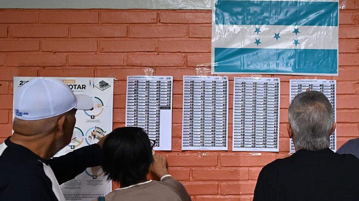 People check where to vote at a polling station during Honduras' general election in Tegucigalpa on November 30, 2025. (Photo by MARVIN RECINOS / AFP via Getty Images)