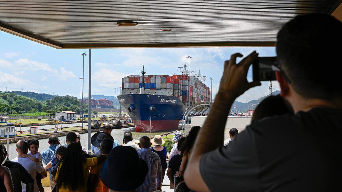 Turistas visitan y toman fotos de un buque portacontenedor en el momento en que cruza una sección del Canal de Panamá, el 6 de septiembre de 2024.
