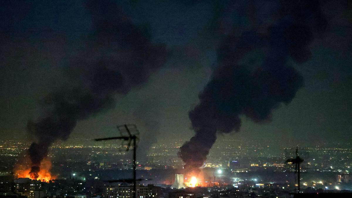 Una alta columna de humo se eleva desde un incendio junto a la Torre Azadi (C) tras ataques cerca del Aeropuerto Internacional de Mehrabad en Teherán el 7 de marzo de 2026.