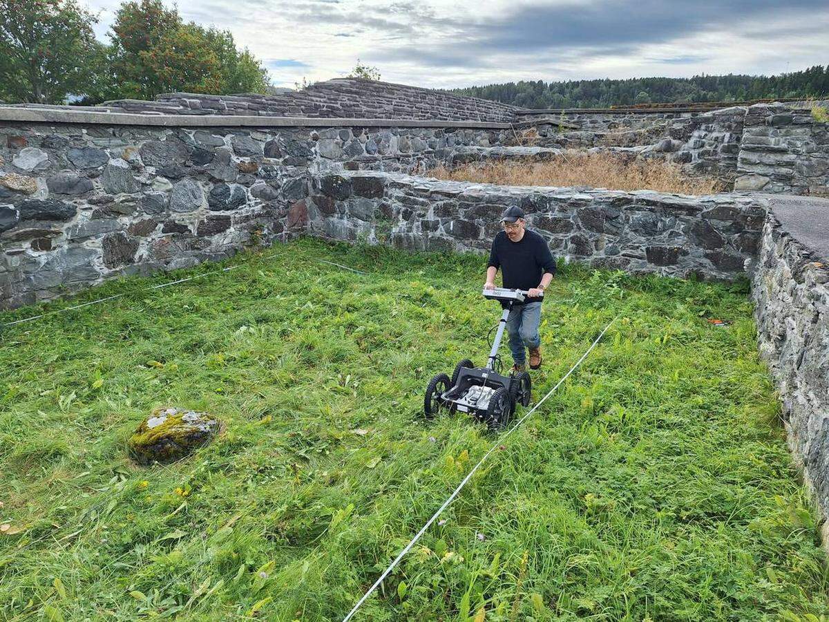 En la foto aparece un investigador cuando escanea con el radar el patio y la silueta marrón de la estructura.